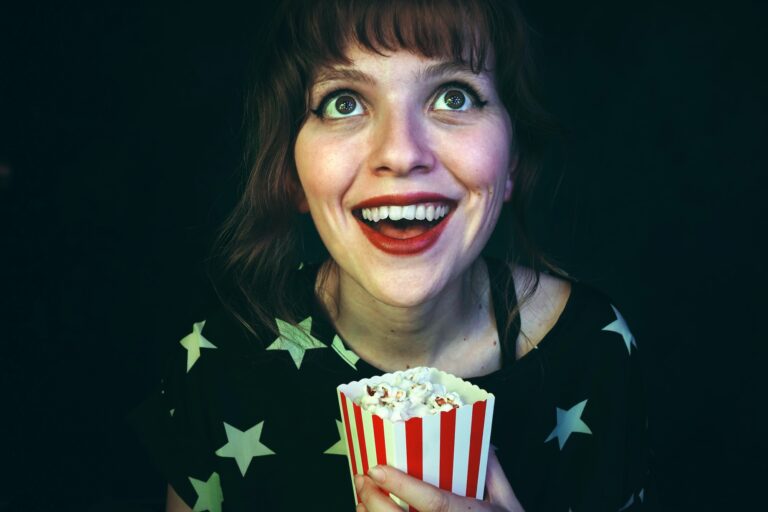 Young woman enjoying a film in a cinema with popcorn